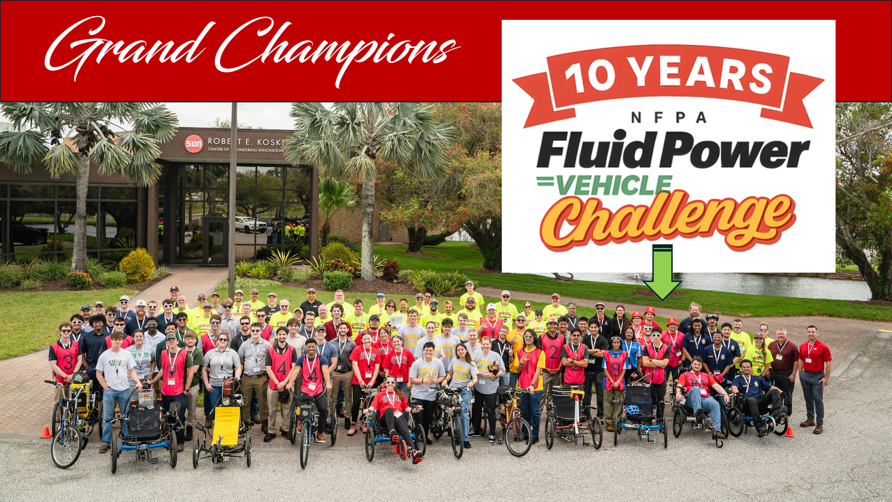 Picture of all competitor for the National Fluid Power Vehicle Challenge with the Grand Champion Team pointed out in the crowd.   The group is in front of the Sun building (sponsors for the event)